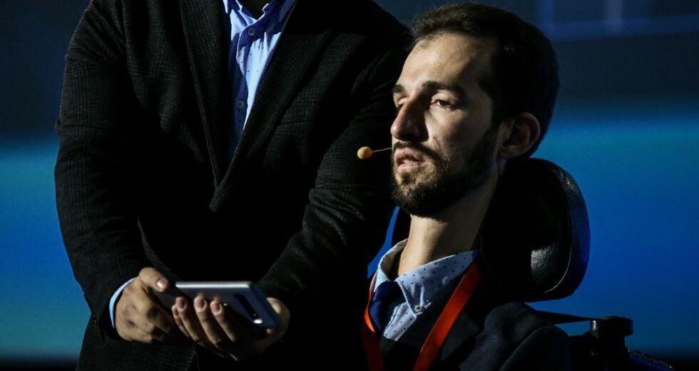 Children with disabilities playing together in an accessible playground, surrounded by inclusive community members and adaptive equipment.